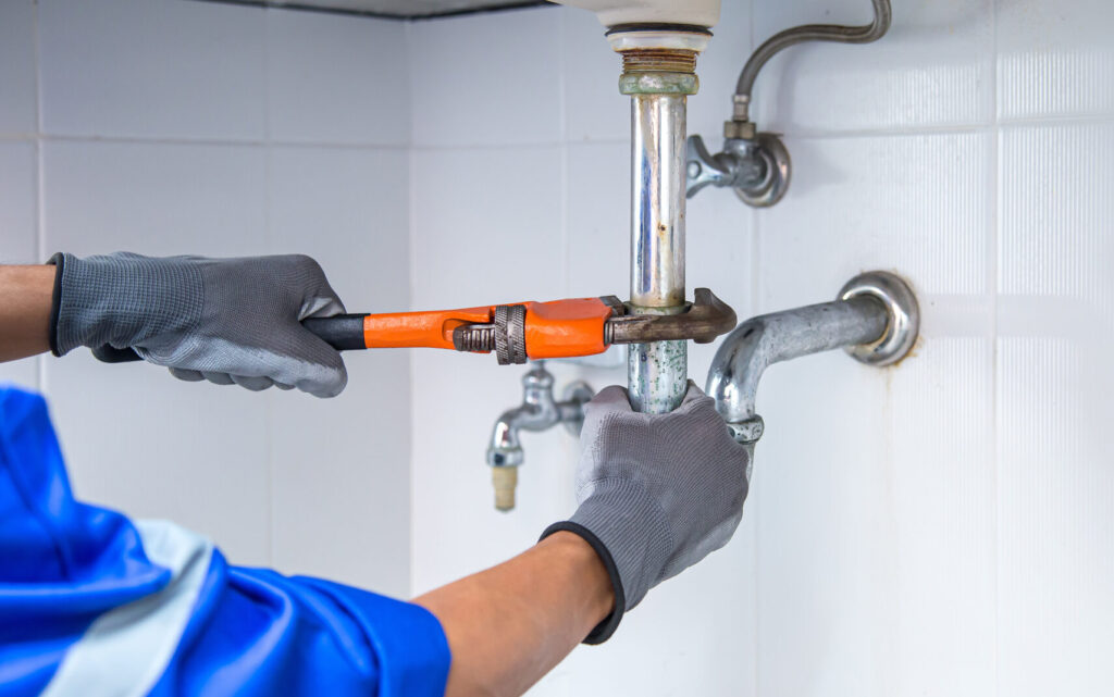 Technician plumbing using a wrench